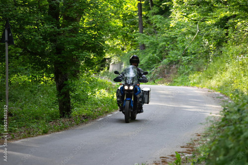 Motorcycle rider on the road in the forest
