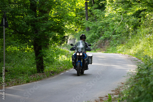 Obraz na płótnie Motorcycle rider on the road in the forest w salonie