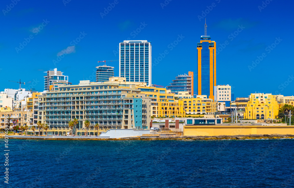 Cityscape of Saint Julian's with modern hotel buildings and skyscrapers viewed from the Sea, Malta