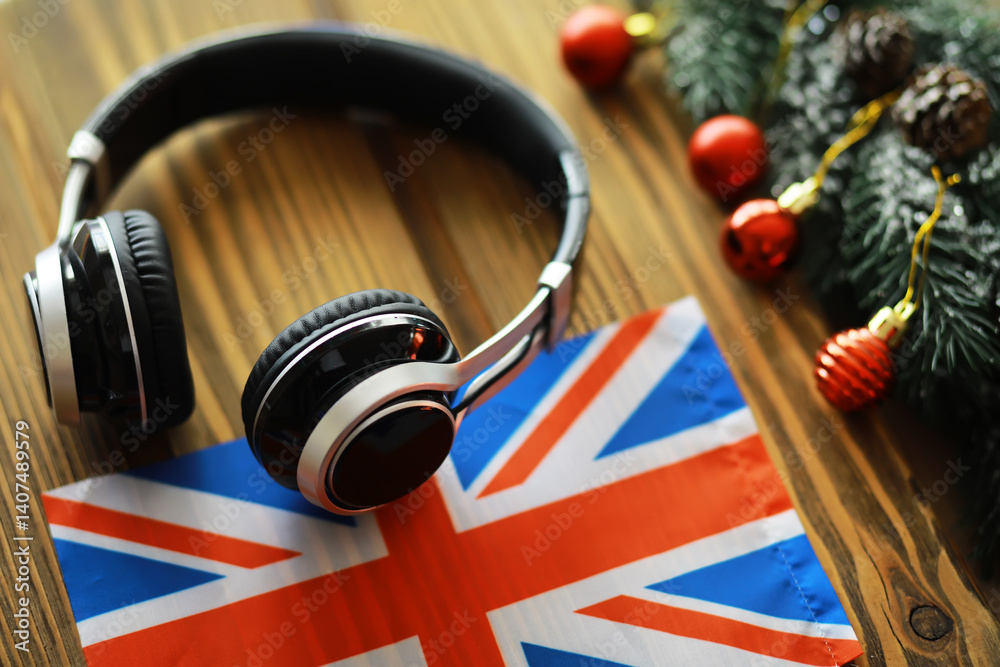 Naklejka premium Headphones on British Flag with Christmas Decorations - Festive Music Holiday Concept
