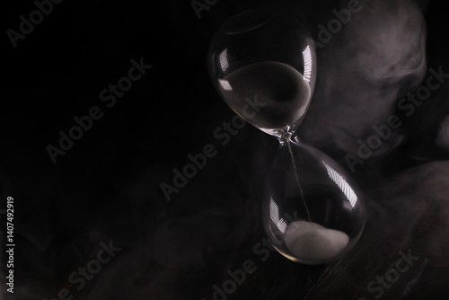 Obraz na płótnie Elegant Timeless Hourglass in Dark Mist, Mysterious Sands Flowing, Symbol of Time and Reflection w salonie