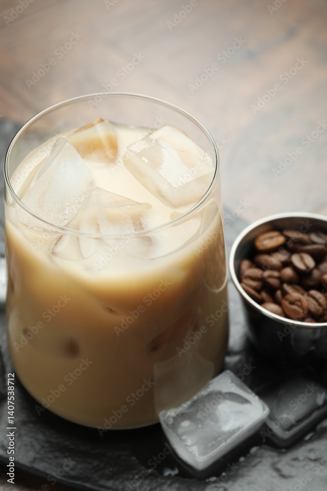 Coffee cream liqueur in glass, ice cubes and beans on table, closeup Coffee cream liqueur in glass, ice cubes and beans on table, closeup