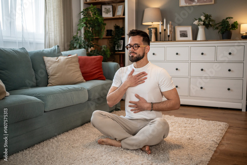 Bild auf Leinwand Man practicing deep breathing exercise at home for stress relief