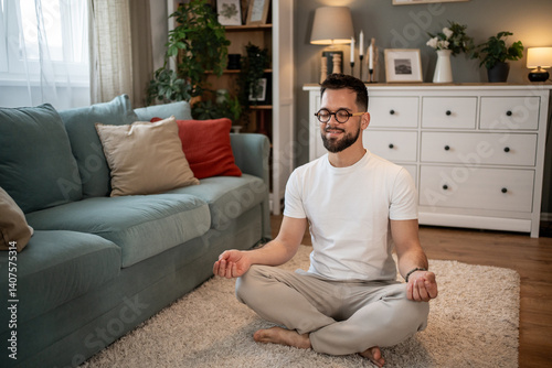 Foto Young man meditating in living room at home: finding inner peace and mindfulness