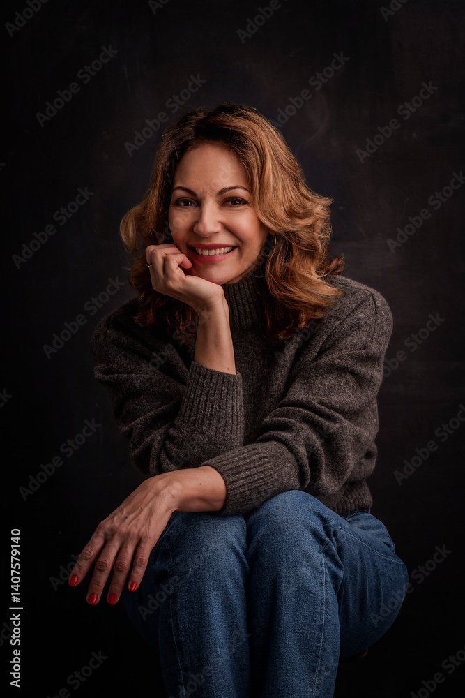 Studio portrait of a mature woman against isolated dark background Studio portrait of a mature woman against isolated dark background