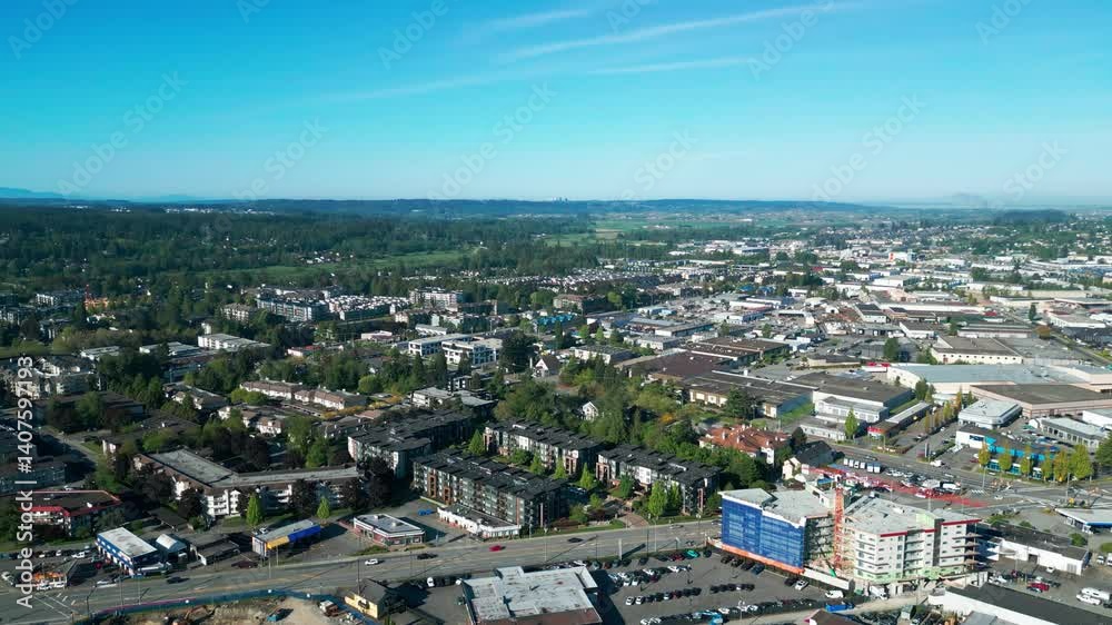 Drone shot of Langley City in Canada, surrounded by green trees under the blue sky. Drone shot of Langley City in Canada, surrounded by green trees under the blue sky.