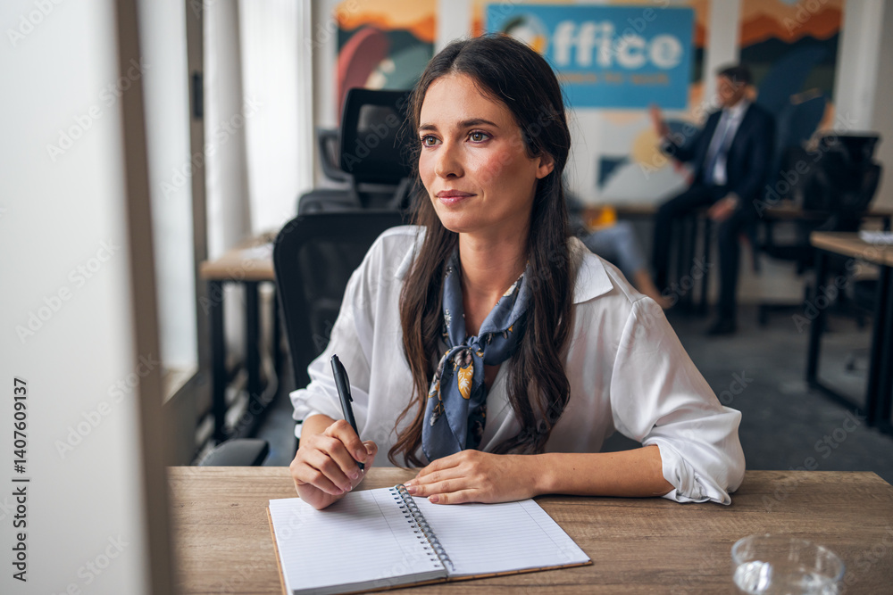 Professional Woman Writing Notes at a Shared Office Workspace