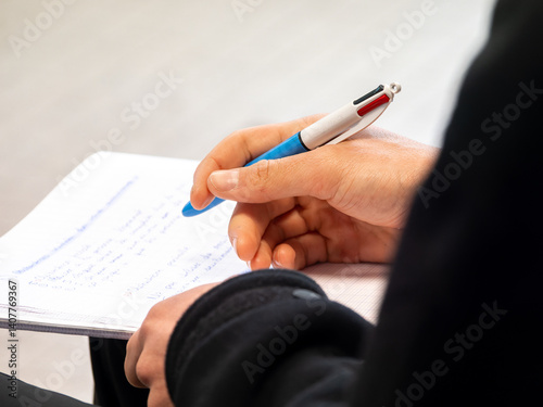 Gros plan sur des mains prenant des notes lors d’une formation PSC1, stylo en main sur feuille de papier