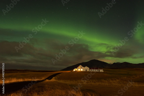 Obraz na płótnie Amazing northern lights with starry sky. Aurora borealis over a lonely house in Iceland w salonie
