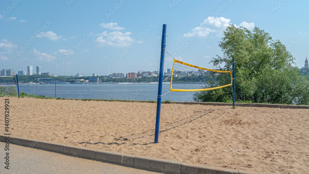 Beach volleyball. A stretched net on a sandy playground. An outdoor team game. Sports and a healthy lifestyle. Beach volleyball court on the river bank. Beach volleyball. A stretched net on a sandy playground. An outdoor team game. Sports and a healthy lifestyle. Beach volleyball court on the river bank.