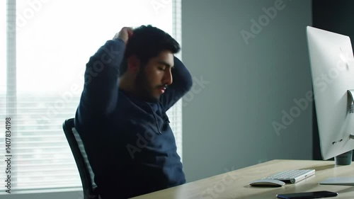 Young Man in Hoodie Looking Down Intently Indoors