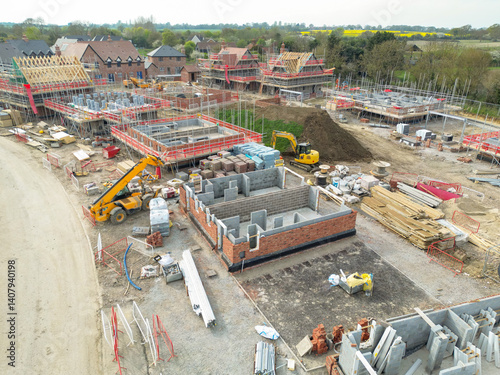 Low level aerial view of a British housing development site in the east of the country. Showing partially built private and smaller, affordable homes. Located in rural Essex.