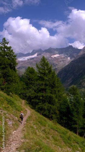 hiker on high altitude mountain trail glacier background italian alps