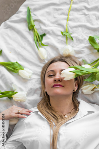 Young woman lying on white bed