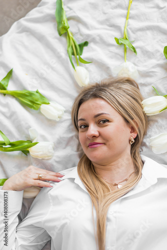 Young woman lying on white bed