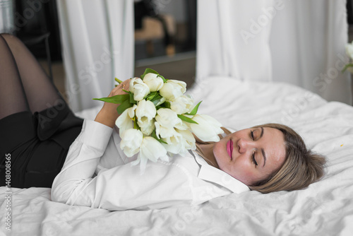 A woman holds white tulips in her hands