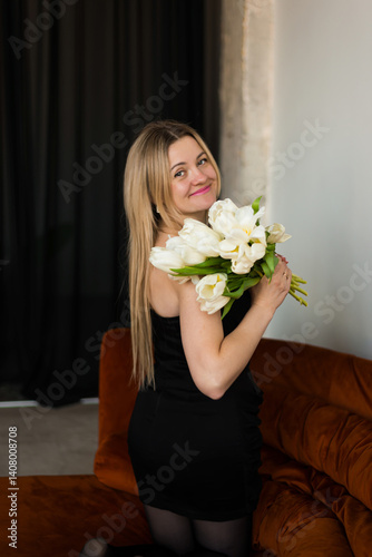 A woman holds white tulips in her hands