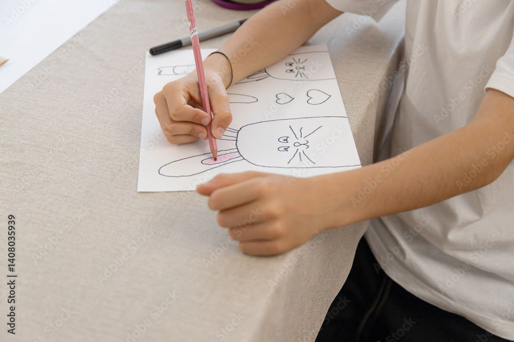 A child traces and colors Easter-themed drawings of bunnies, carrots and hearts during a fun and creative activity at home. Improving fine motor skills. A child traces and colors Easter-themed drawings of bunnies, carrots and hearts during a fun and creative activity at home. Improving fine motor skills.