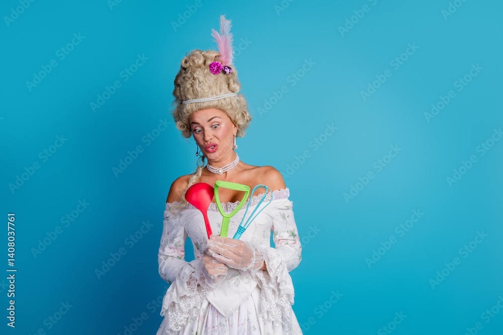 Fototapeta premium Charming woman in a styled baroque costume holding modern kitchen utensils, blending historical fashion with contemporary objects