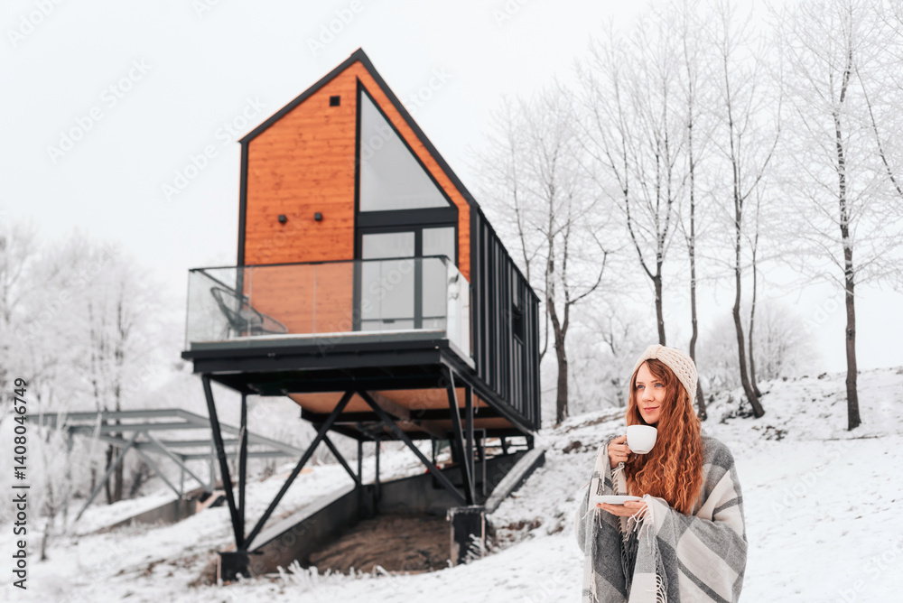 Woman Drinking Coffee by Log Cabin in Winter