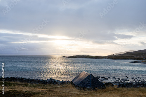 The Norwegian landscape unfolds in its full beauty, with towering mountains perfectly mirrored in the calm waters of a fjord. The natural mirror of the water captures every detail of the surroundings,