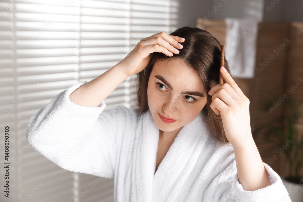 Beautiful woman combing her hair with healthy roots at home Beautiful woman combing her hair with healthy roots at home
