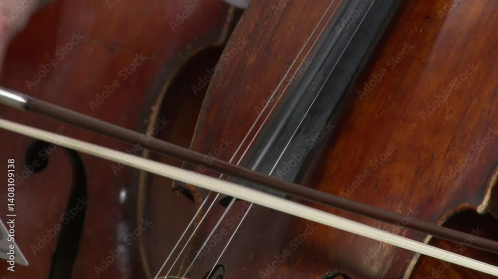 A musician plays the cello. Close-up of the hands of an informal musician playing the cello during a concert. Cellists perform at a concert. A musician plays the cello. Close-up of the hands of an informal musician playing the cello during a concert. Cellists perform at a concert.
