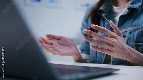 Young asian businesswoman using laptop computer for online video conference meeting with her team sit at desk in office. Female worker talking with business partners while having video conference.