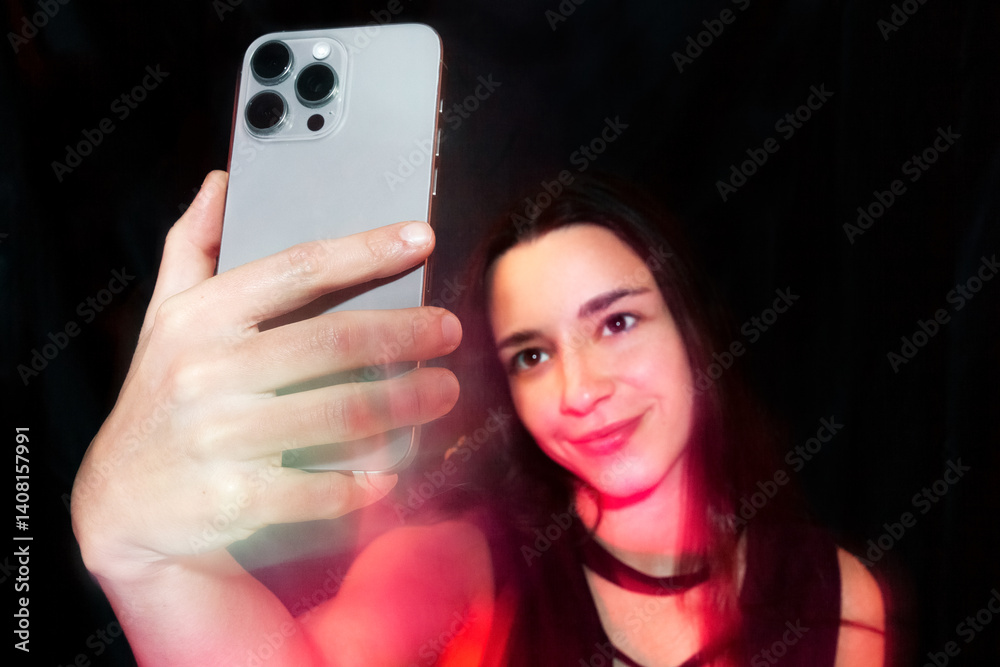 Woman Taking Selfie with Smartphone Against Black Background Woman Taking Selfie with Smartphone Against Black Background