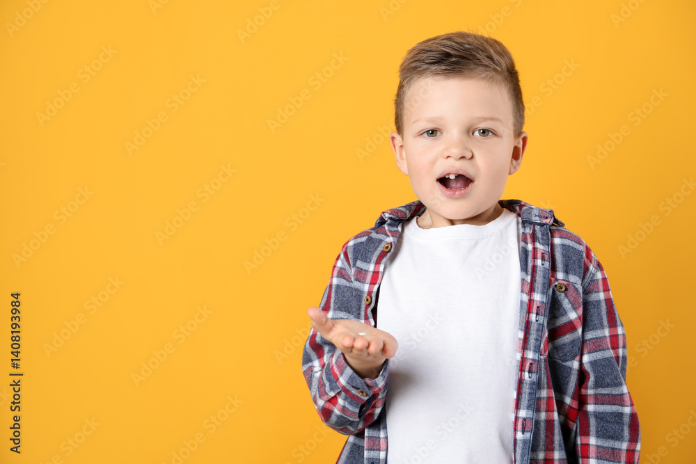 Cute little boy with missing tooth on orange background, space for text. Waiting for tooth fairy Cute little boy with missing tooth on orange background, space for text. Waiting for tooth fairy