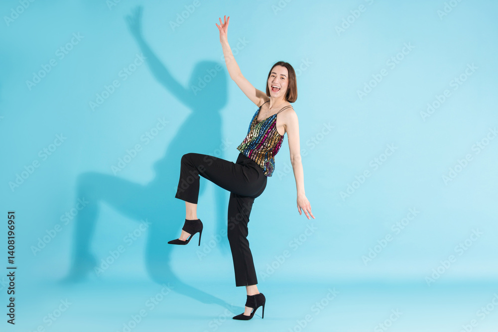 Obraz premium Happy woman dancing on light blue background