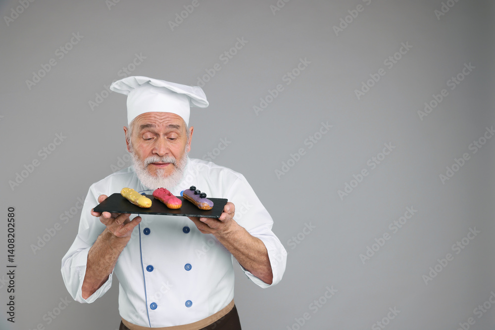 Professional pastry chef with delicious eclairs on grey background, space for text Professional pastry chef with delicious eclairs on grey background, space for text