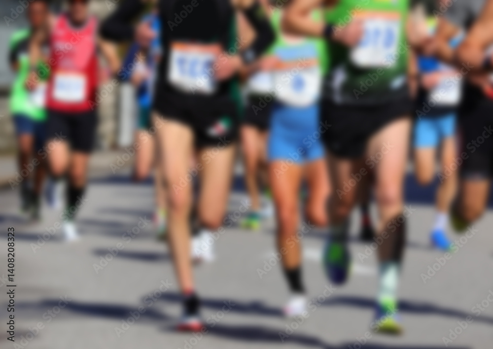Fototapeta premium Intentionally blurred scene of runners during a road race on the asphalt road