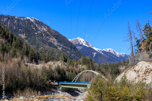 Obraz na płótnie Mountain bridge crossing alpine river in early spring landscape.. w salonie