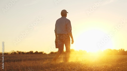 Farmer walking through wheat field in rubber boots, , agriculture, business of the golden grain, farmer s life: a wheat story, sowing seeds of success, the art of wheat harvesting, farmer's autumn photo
