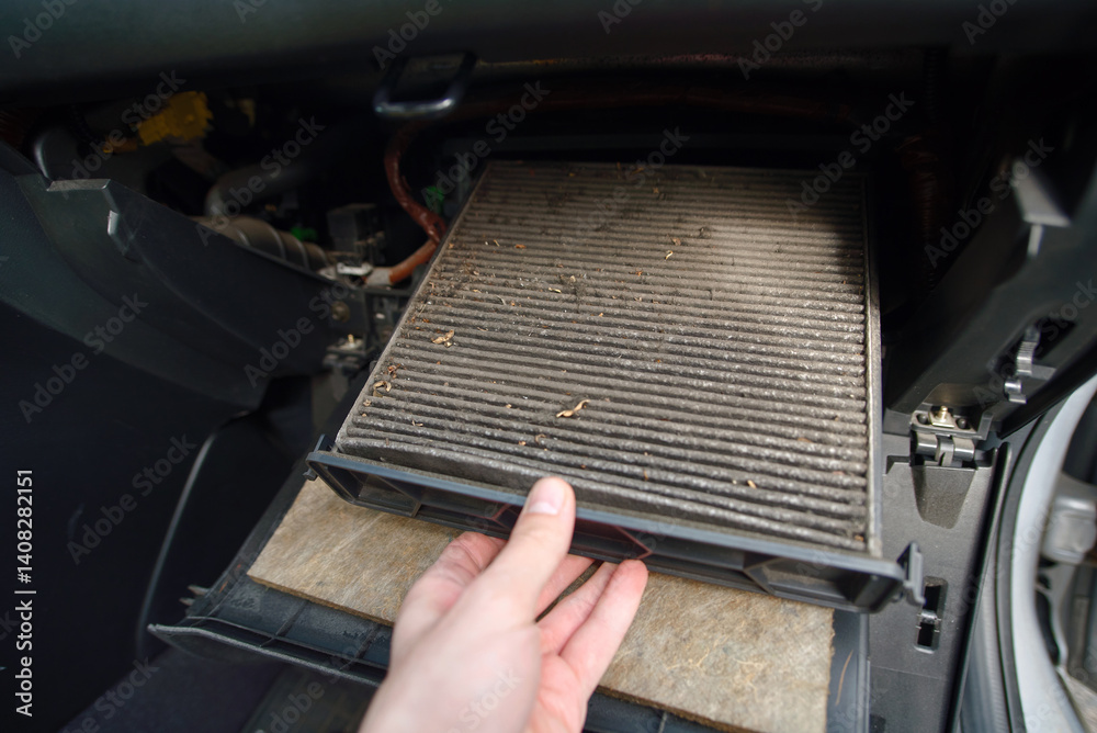 Removing contaminated vehicle cabin filter during inspection to improve air conditioning system performance and eliminate allergens from circulating. Hand extracting heavily used cabin filter