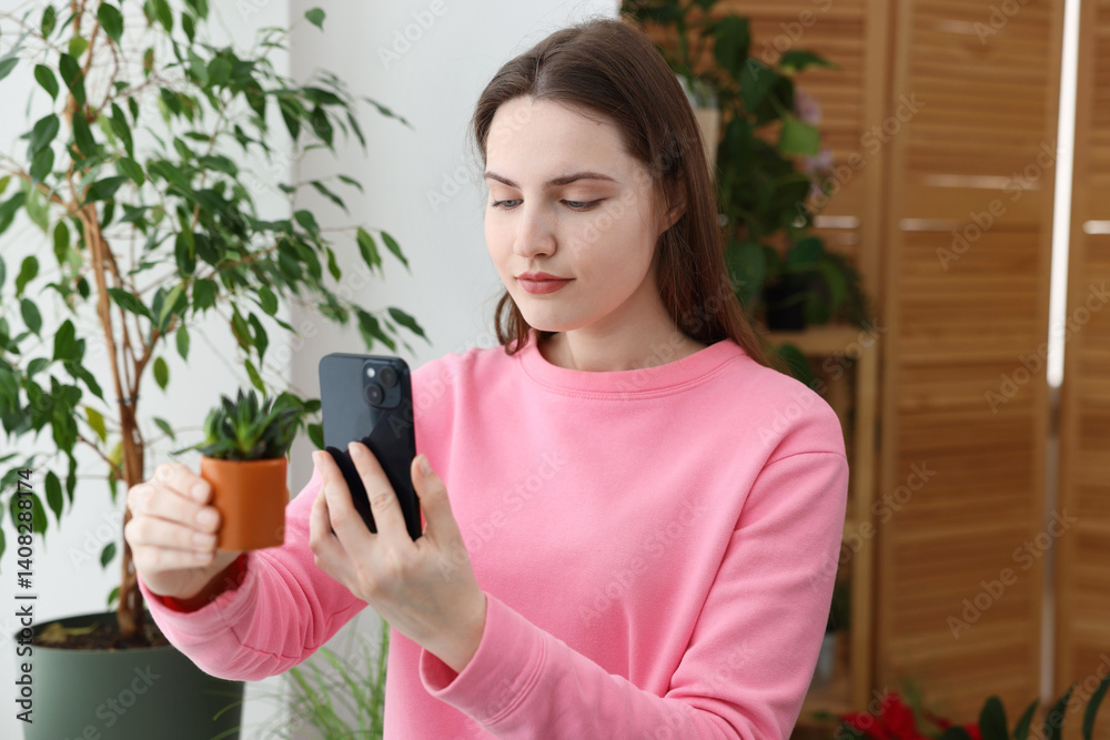 Woman using houseplant recognition application on smartphone indoors Woman using houseplant recognition application on smartphone indoors
