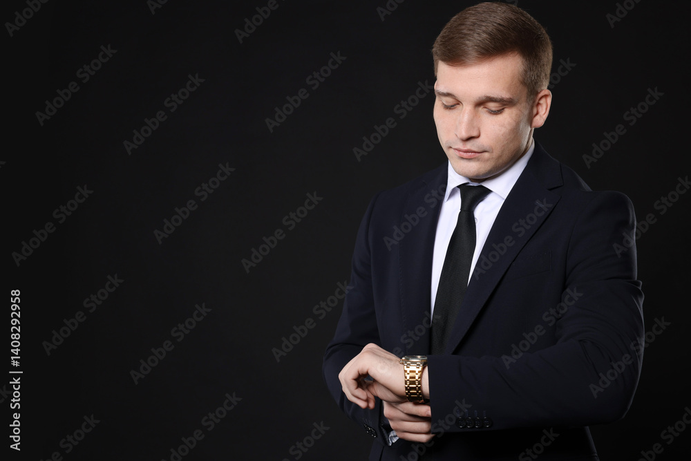 Man in classic suit checking time on black background. Space for text Man in classic suit checking time on black background. Space for text