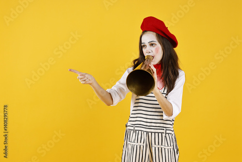 Cute girl dressed like mime with megaphone pointing at something on yellow background, space for text. Surprise party