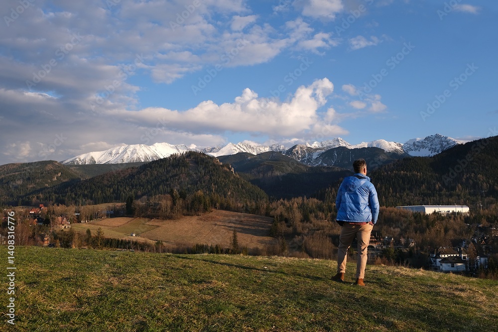 Naklejka premium Silhouette of standing man in blue jacket on beautiful viewpoint with Tatras mountains on Antalowka, Zakopane, Poland