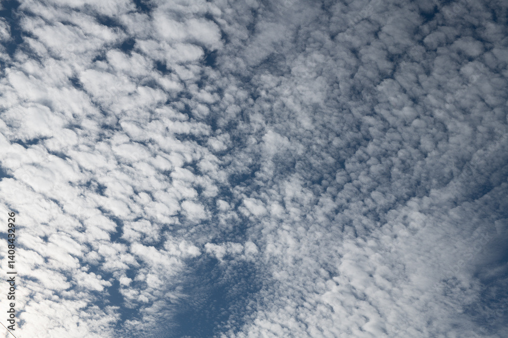 White altocumulus clouds covering blue sky on sunny day White altocumulus clouds covering blue sky on sunny day