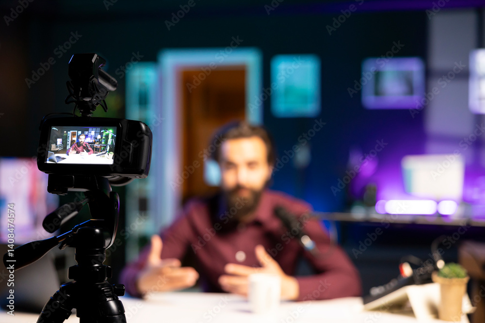 Focus on professional recording equipment used by happy influencer in blurry background to film for online streaming platforms. Close up on camera used by man to record video