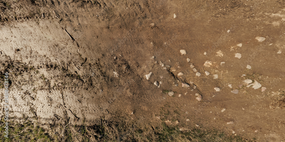 view from above on surface of texture of dry road with tractor tire tracks in countryside