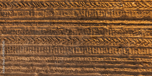 Obraz na płótnie view from above on surface of texture of dry road with tractor tire tracks in countryside w salonie