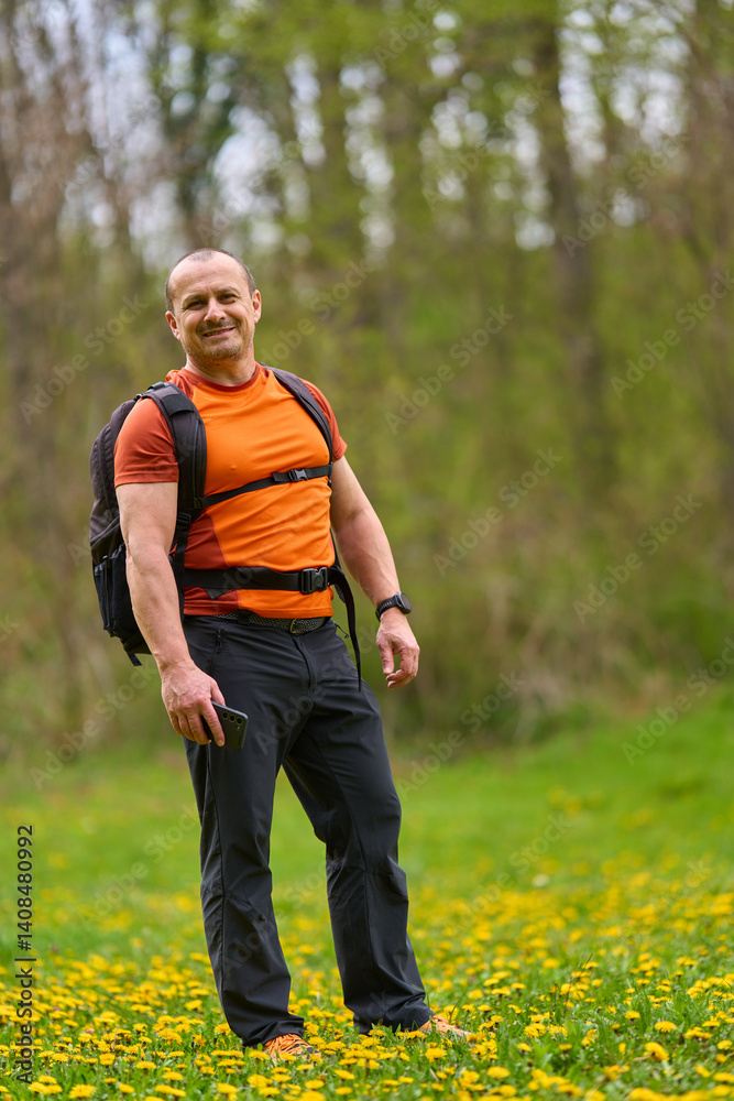 Happy man hiking in spring meadow