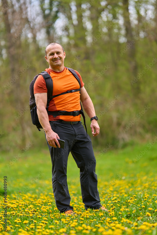 Happy man hiking in spring meadow