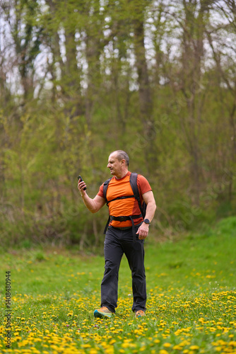 Obraz na płótnie Man hiking with phone in meadow w salonie