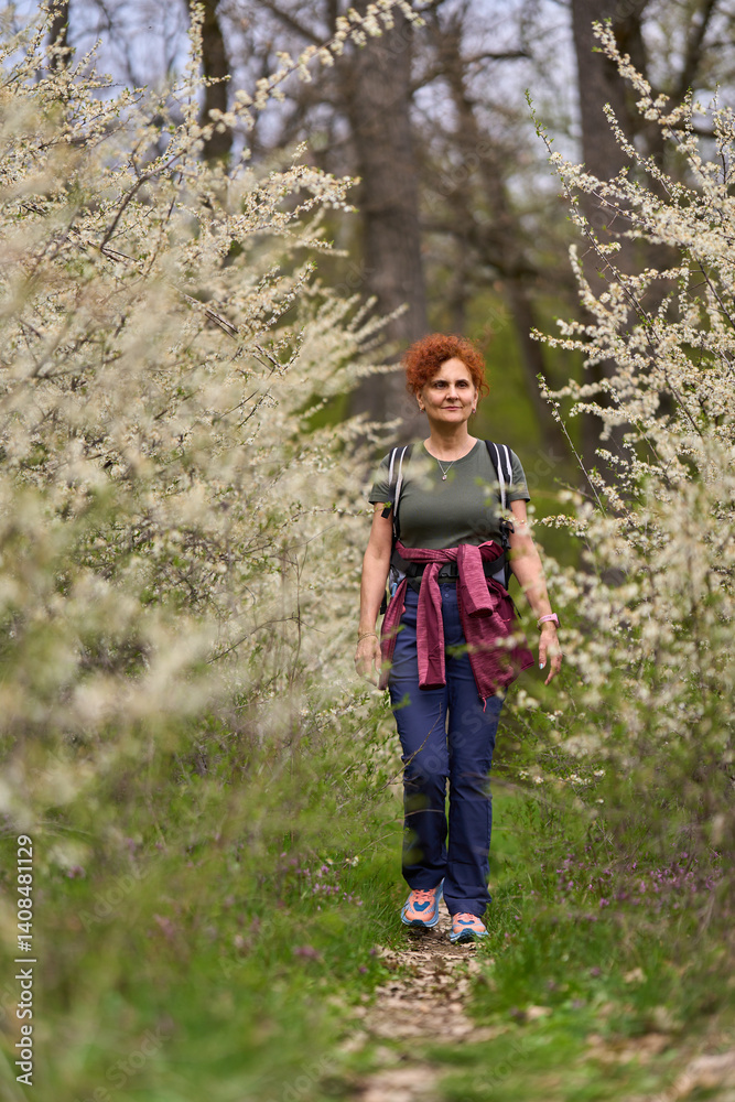 Woman walking through blooming blackthorn