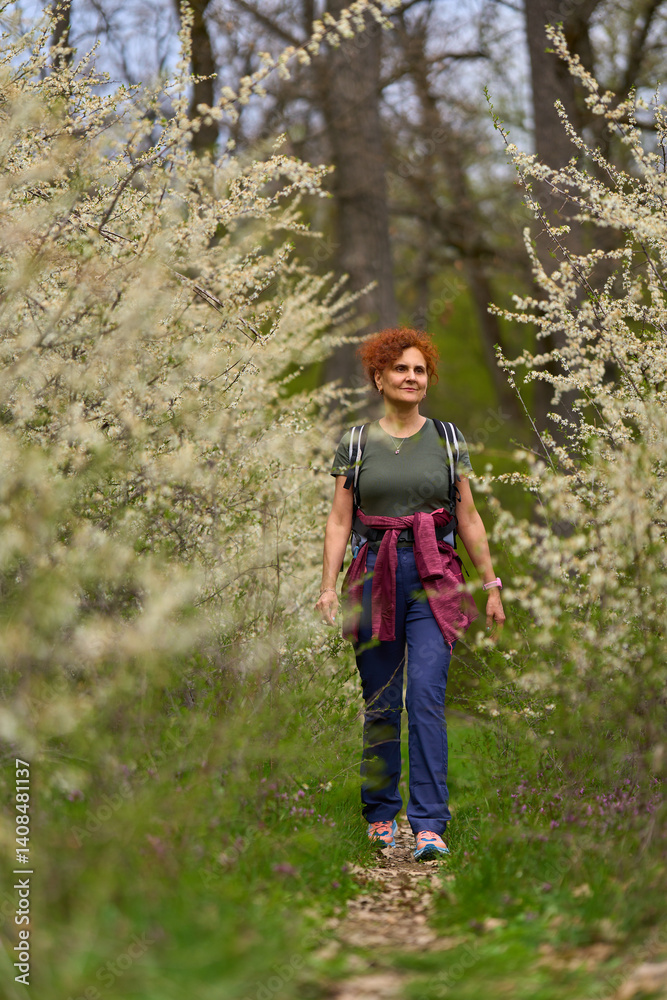 Woman walking through blooming blackthorn