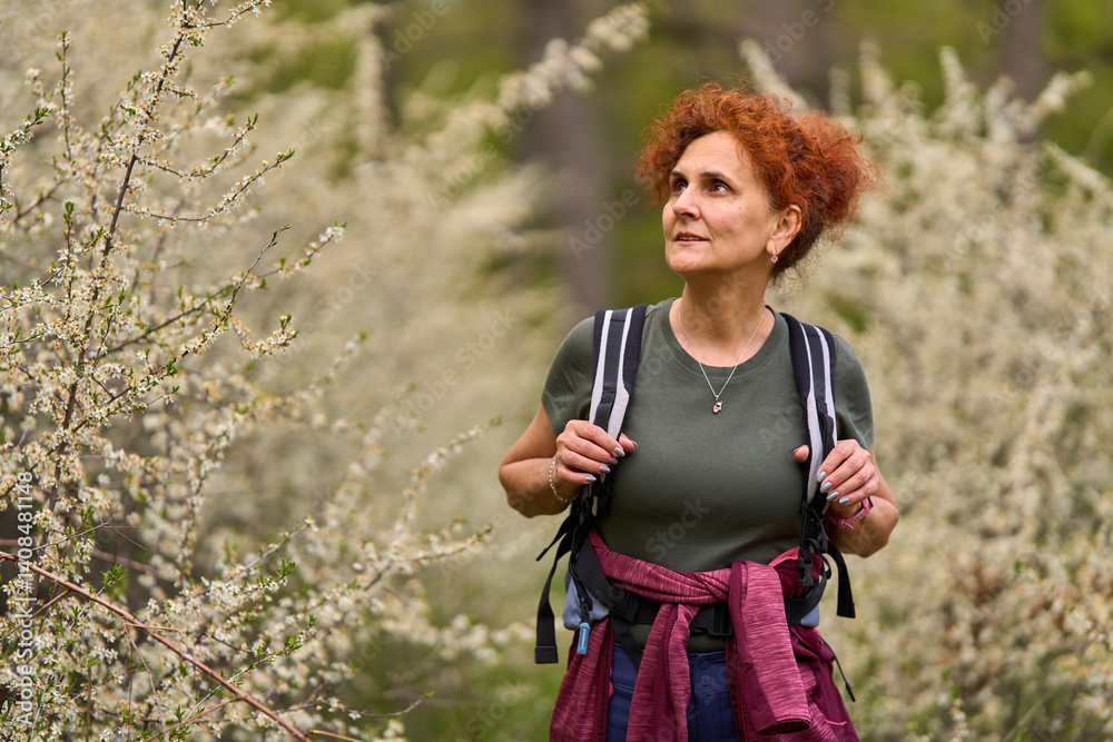 Woman walking through blooming blackthorn